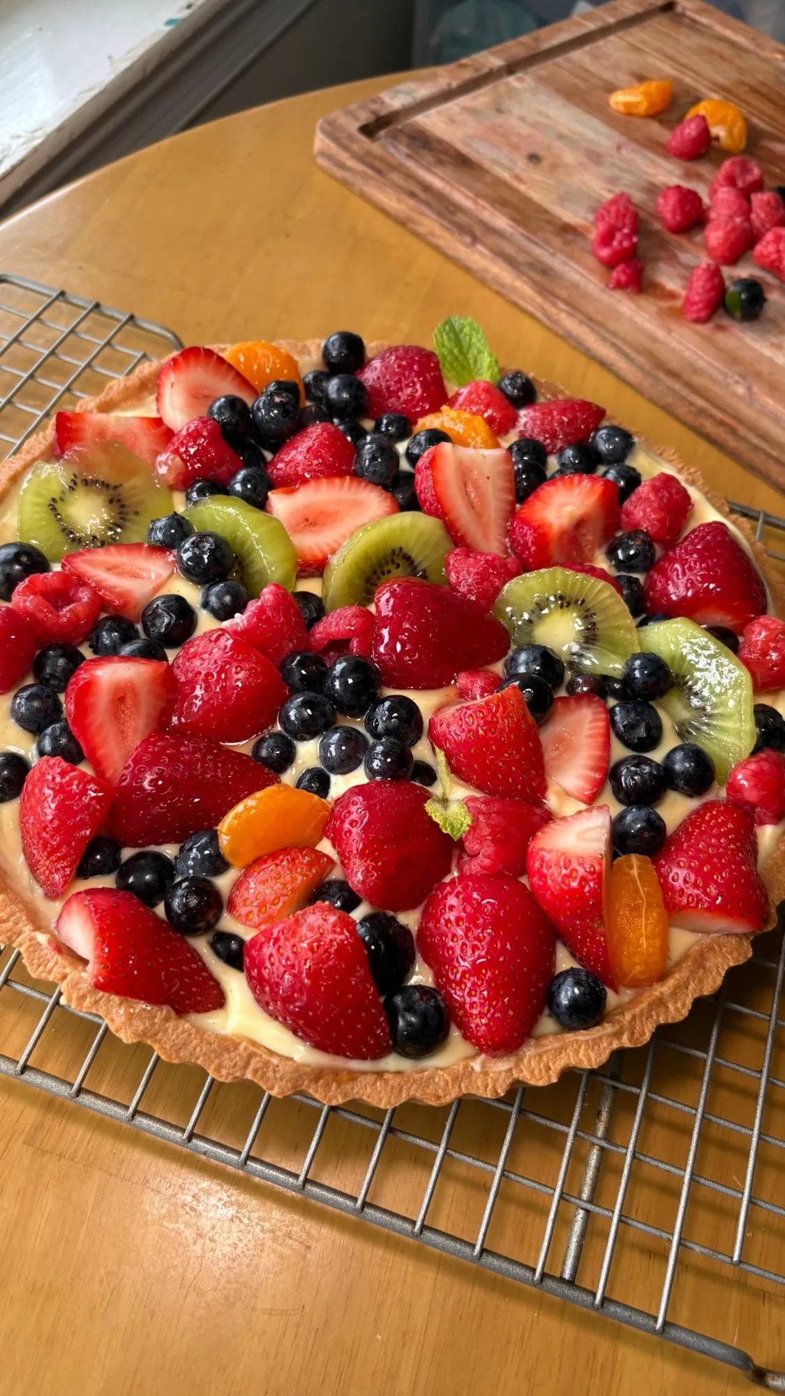 Fruit tart with custard, strawberries, blueberries, kiwi, and mandarin segments