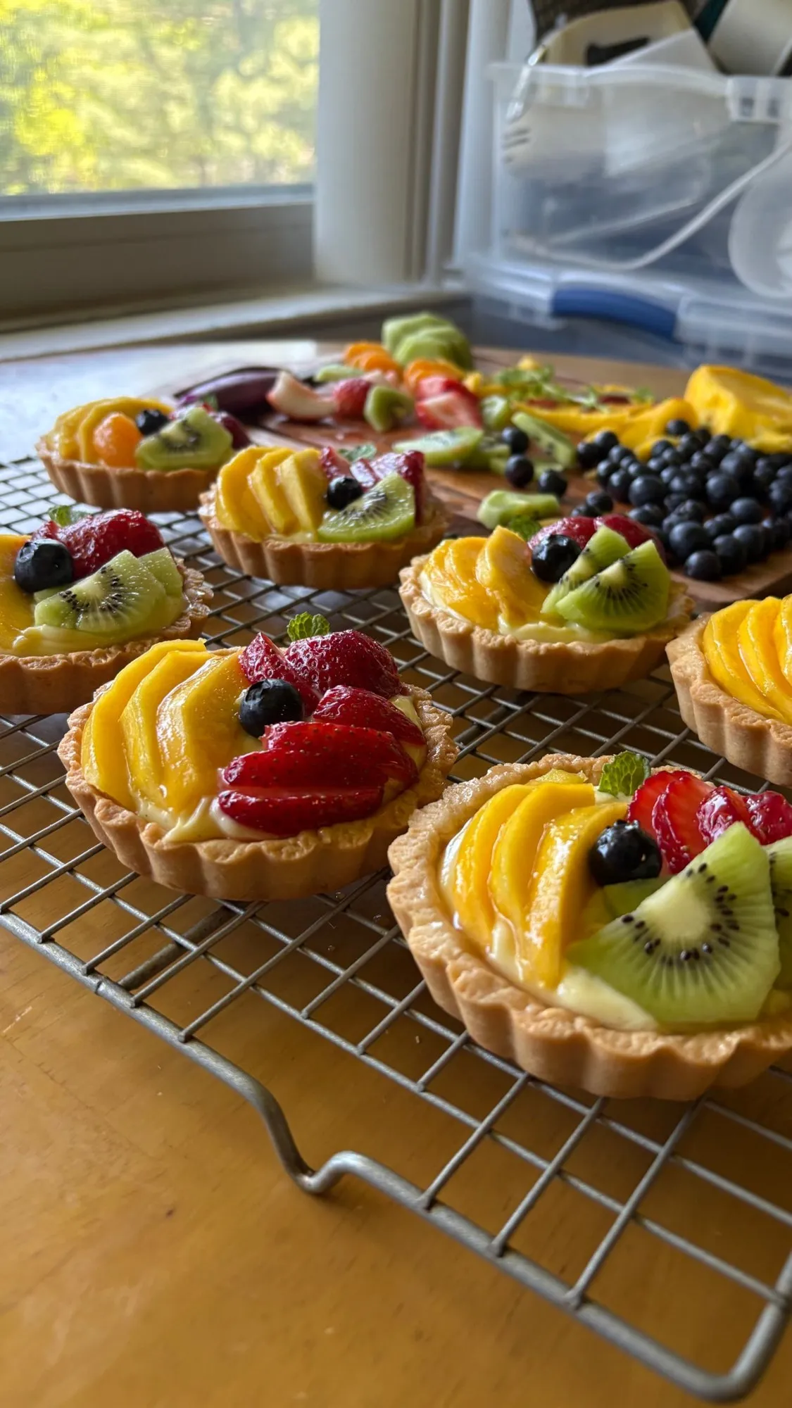 Mini tarts with pastry cream, mango, strawberry, kiwi, blueberry, and fresh mint